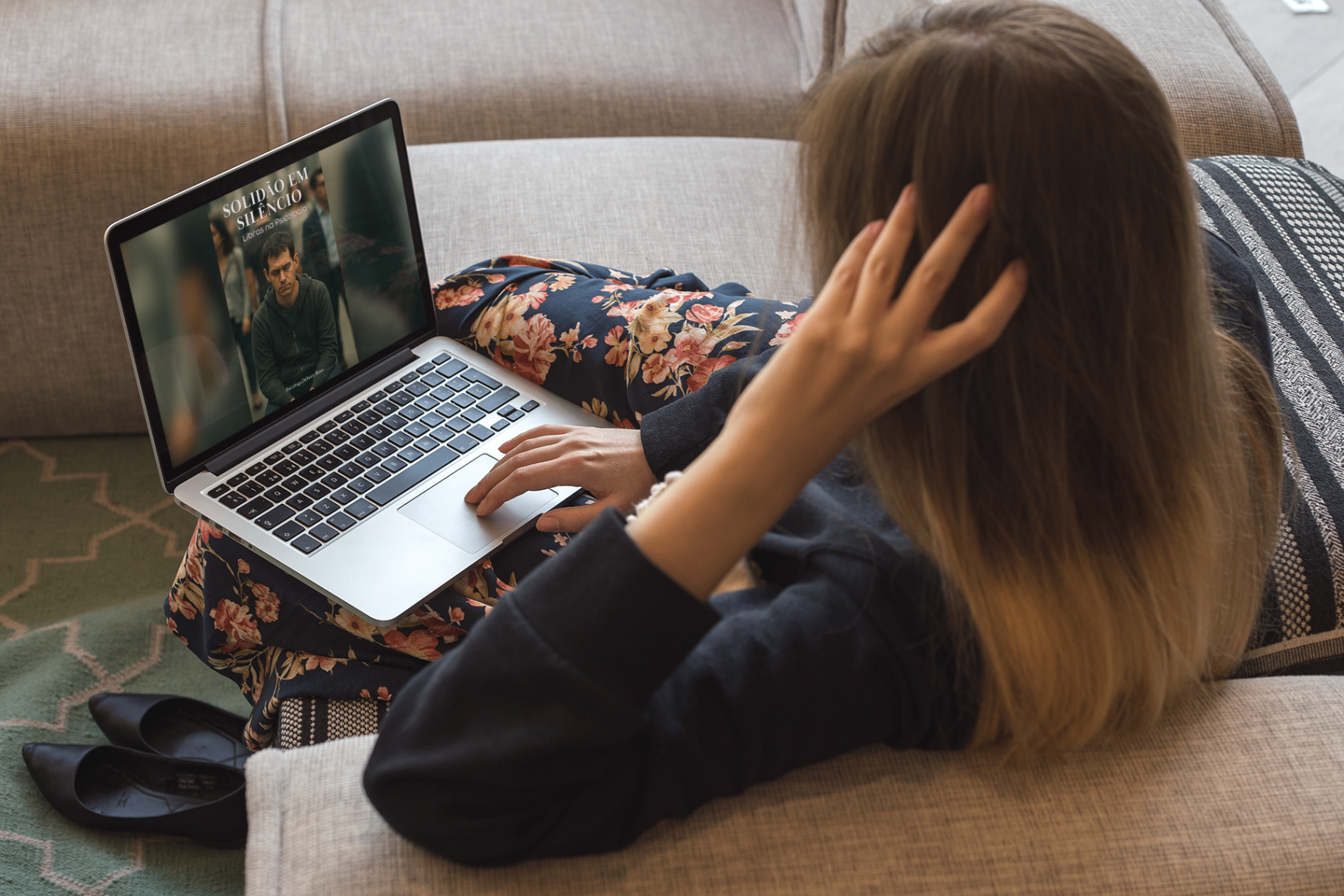 Mulher lendo Solidão em Silêncio no notebook em casa